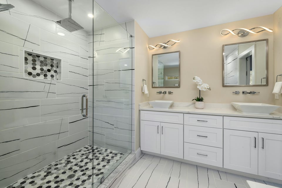Contemporary bathroom with glass shower and double vanity in a Minnetonka, MN custom home by Willet Remodeling and Construction.