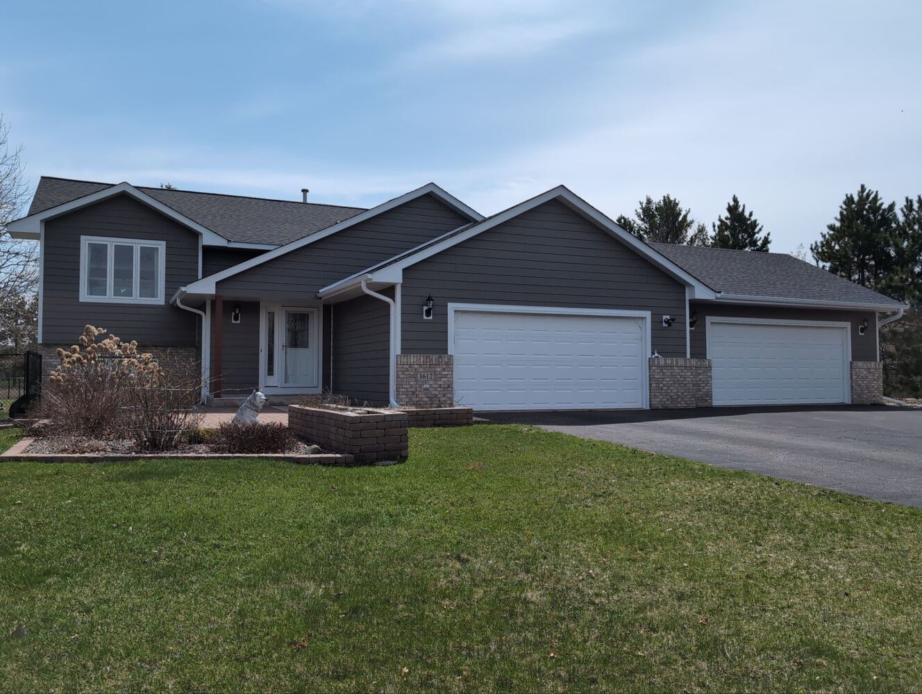Front view of remodeled home with new siding and driveway in Ramsey, MN by Willet Remodeling and Construction.