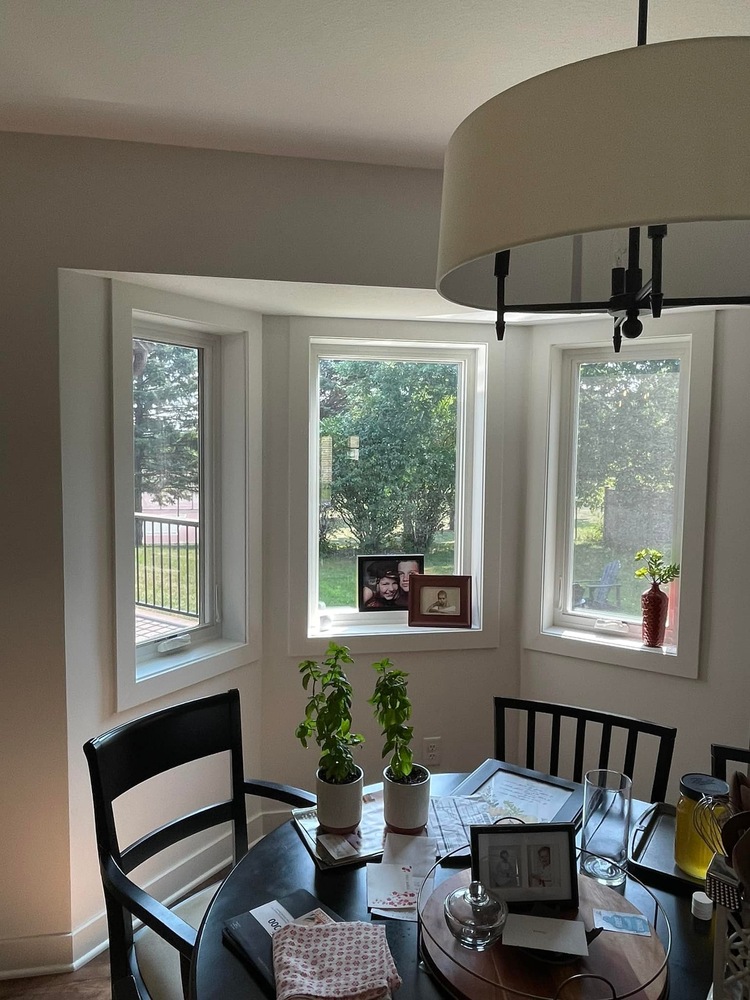 Sunlit breakfast area with bay windows in a custom home remodel by Willet Remodeling and Construction in Cedar, MN.
