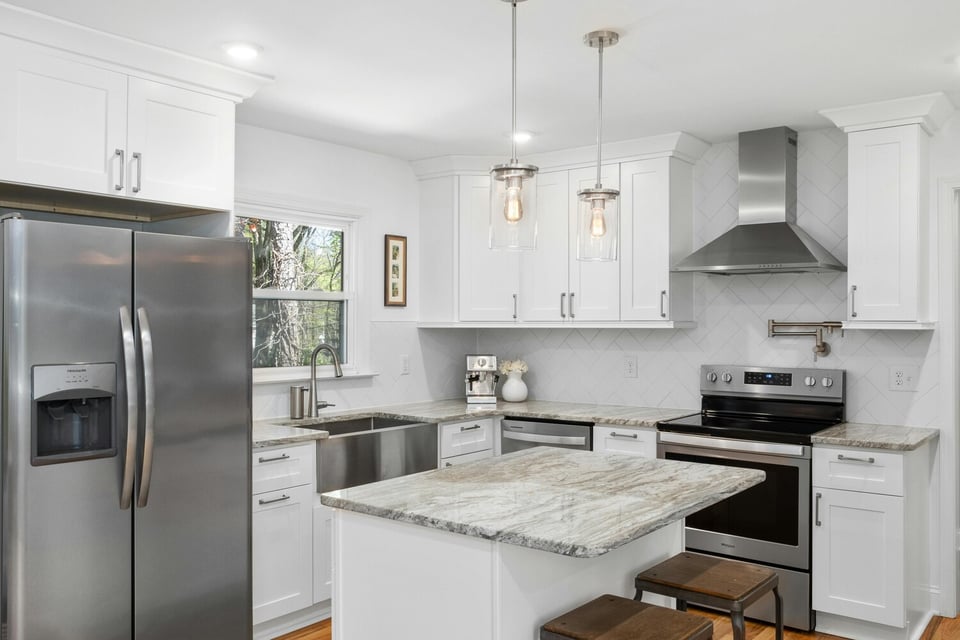 Stock Photo of Bright kitchen with island and stainless range hood in a custom Andover, MN home.