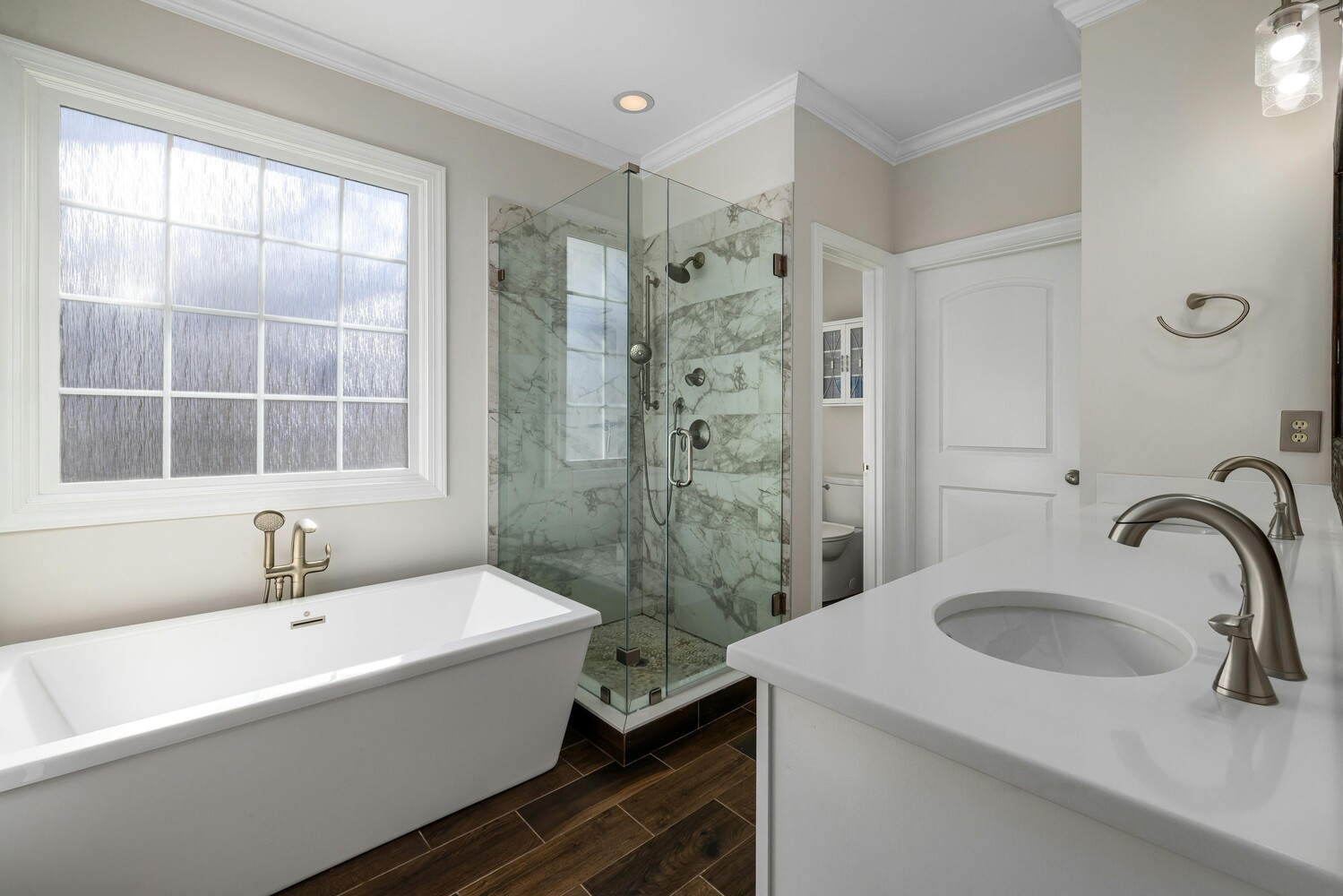 Stock Photo of Elegant primary bathroom featuring walk-in shower and soaking tub in Cedar, MN.