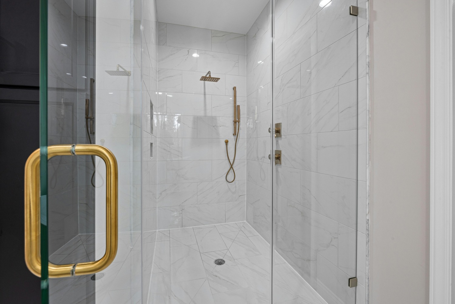 Stock Photo of Elegant walk-in shower with marble tile and brass fixtures in a custom home in Ramsey, MN.