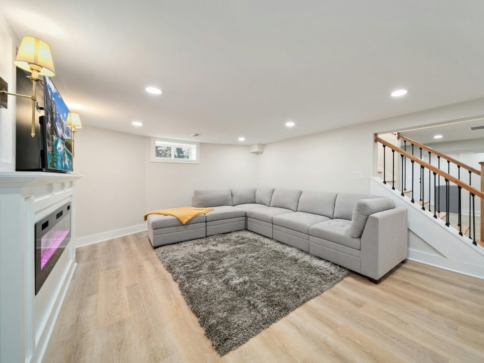 Stock Photo of Fully finished lower level with warm wood flooring and entertainment setup in Saint Francis, MN.