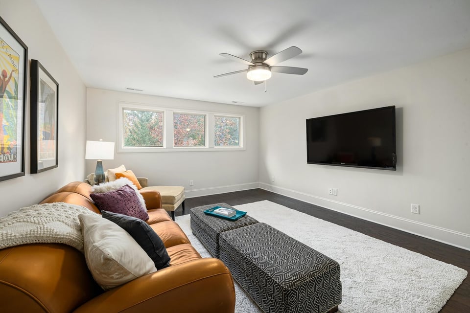 Stock Photo of Lower-level remodel featuring cozy lounge and mounted TV in Ham Lake, MN.