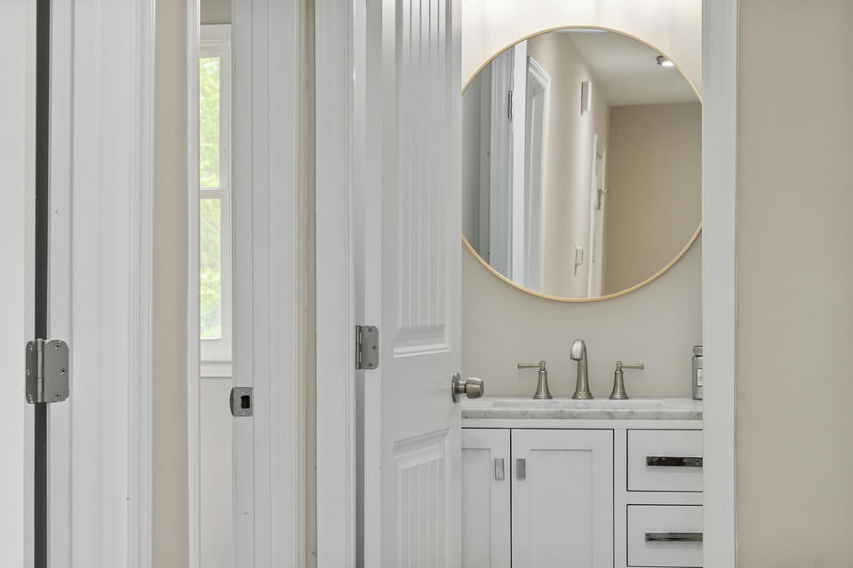 Stock Photo of Small bathroom vanity with round mirror in an East Bethel, MN custom home.