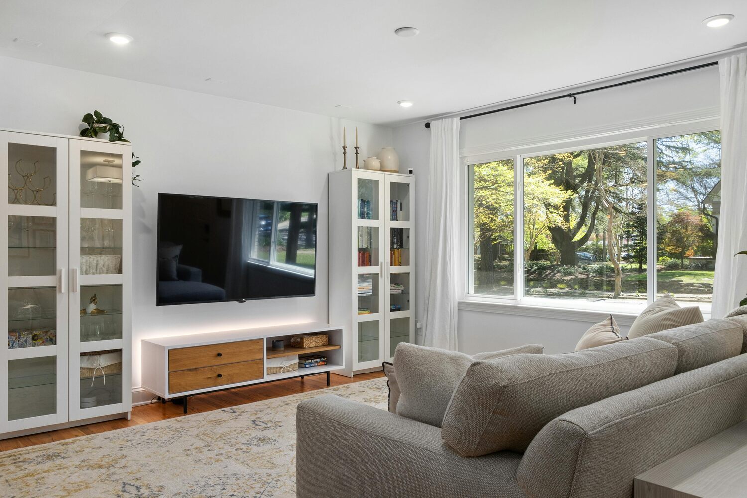 Stock Photo of Stylish living room with large window and mounted TV in a custom home in Anoka, MN.