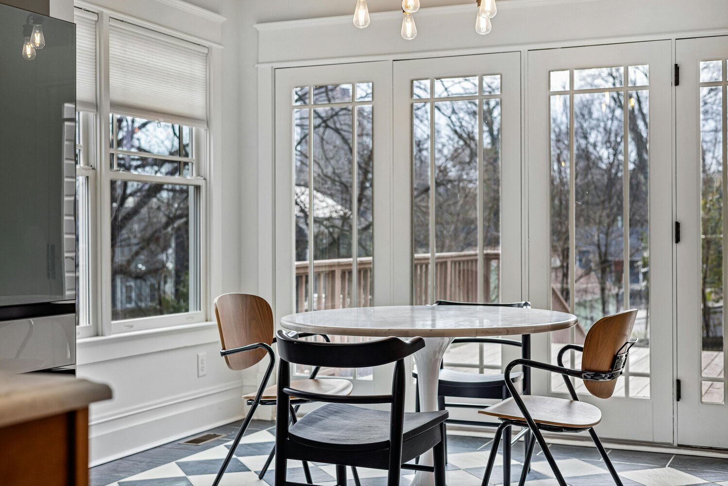 Stock Photo of Sunlit breakfast area featuring large windows and chic decor in Edina, MN.