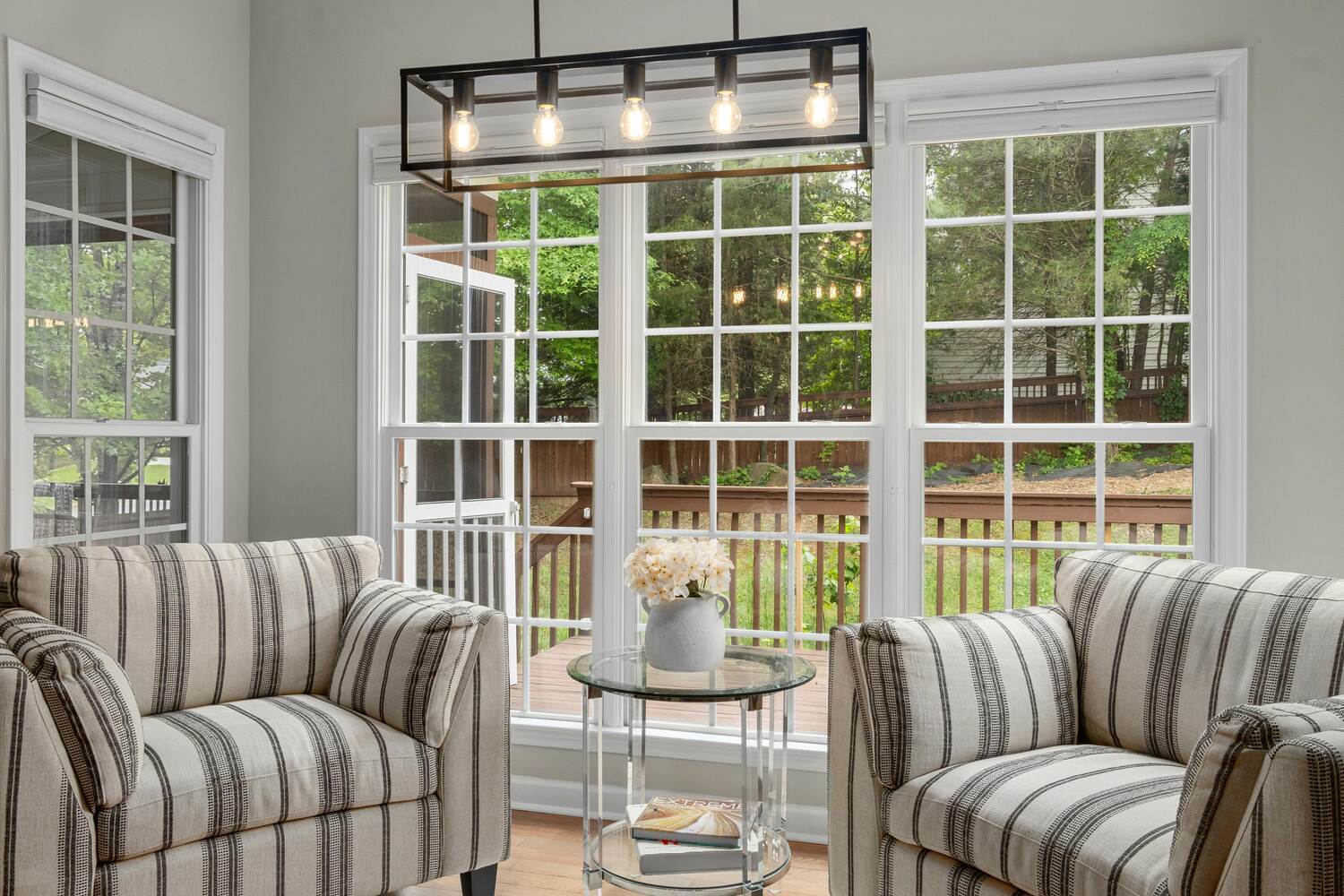 Stock Photo of Sunroom with striped chairs and backyard view in a custom home in Edina, MN.