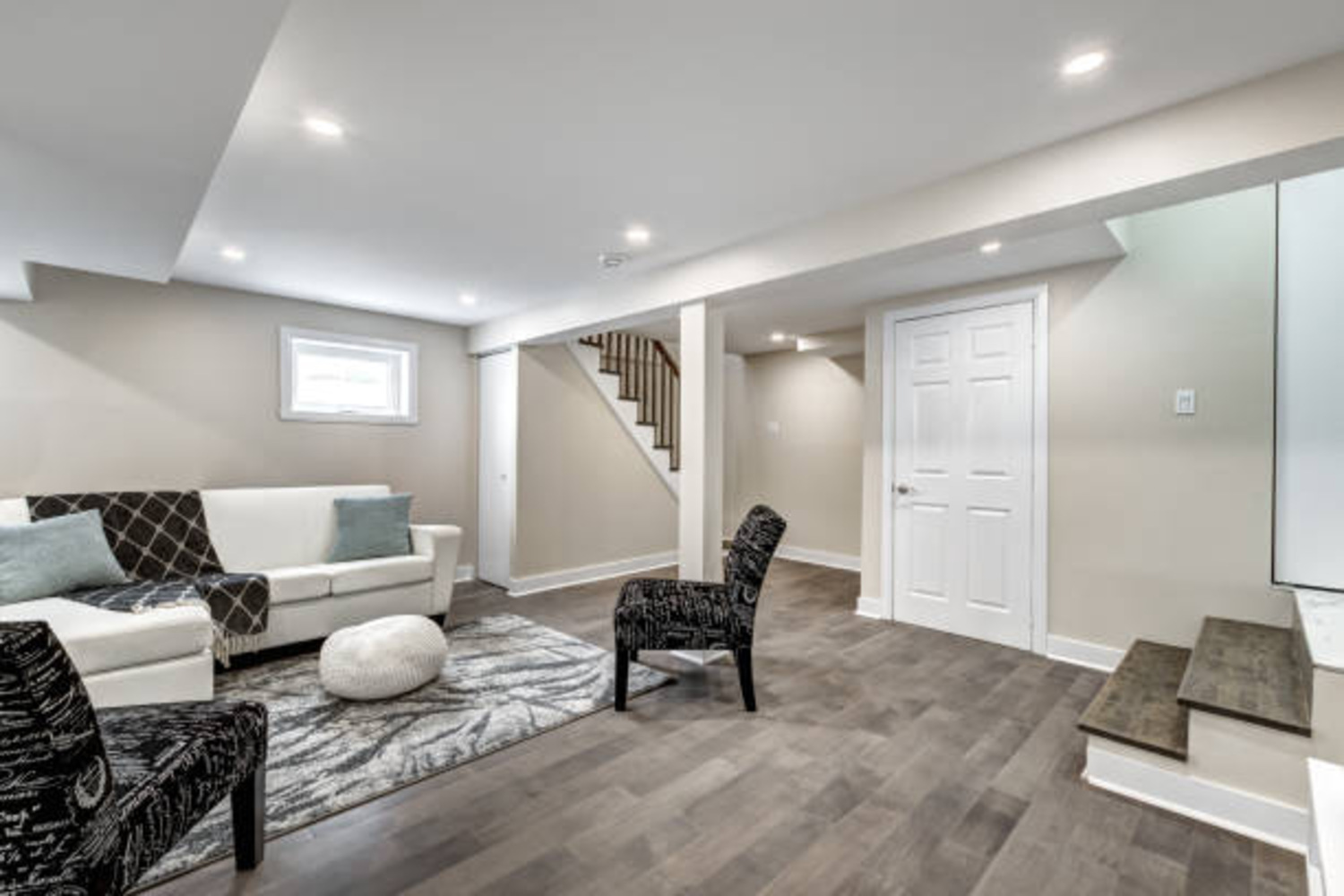 Stock Photo of Updated basement remodel with dark floors and bright walls in East Bethel, MN.