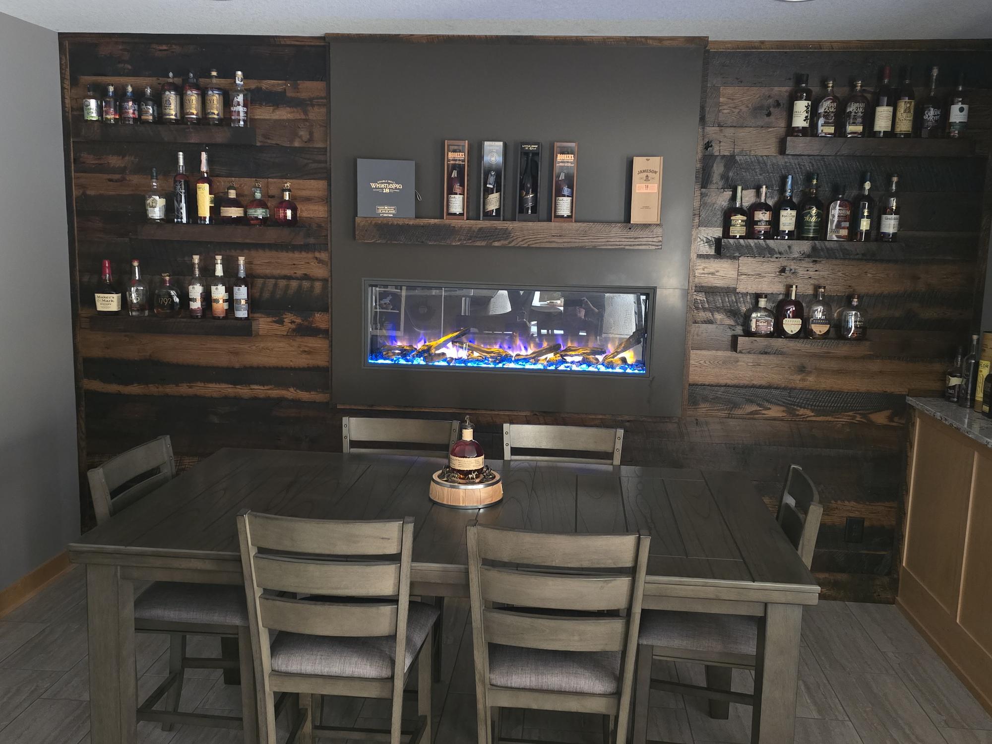 Basement bar and whiskey lounge with electric fireplace in a custom home in Ramsey, MN by Willet Remodeling and Construction.