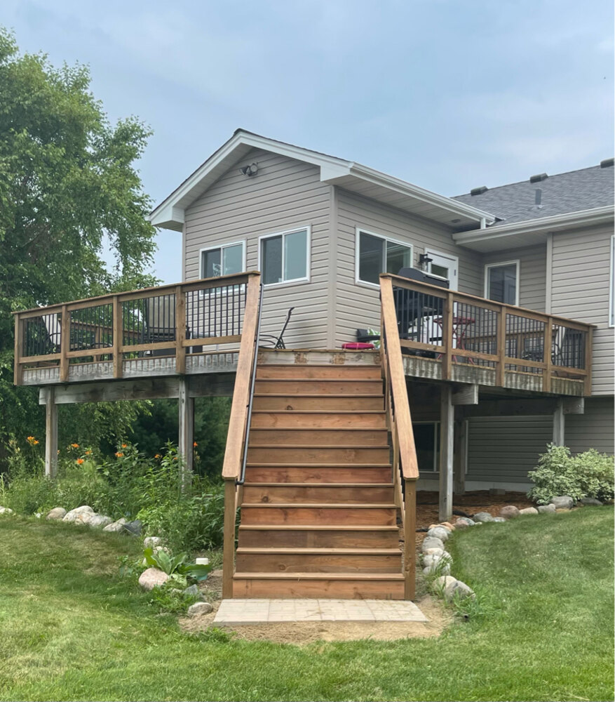 Exterior view of elevated custom home addition with wooden stairs in Anoka, MN by Willet Remodeling and Construction.