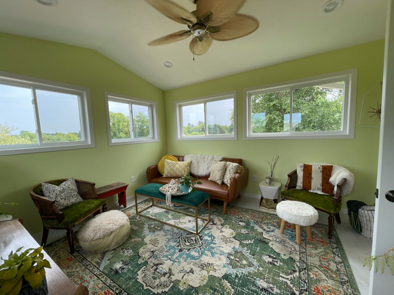 Vibrant sunroom with eclectic furniture in a custom home project in Columbus, MN by Willet Remodeling and Construction.