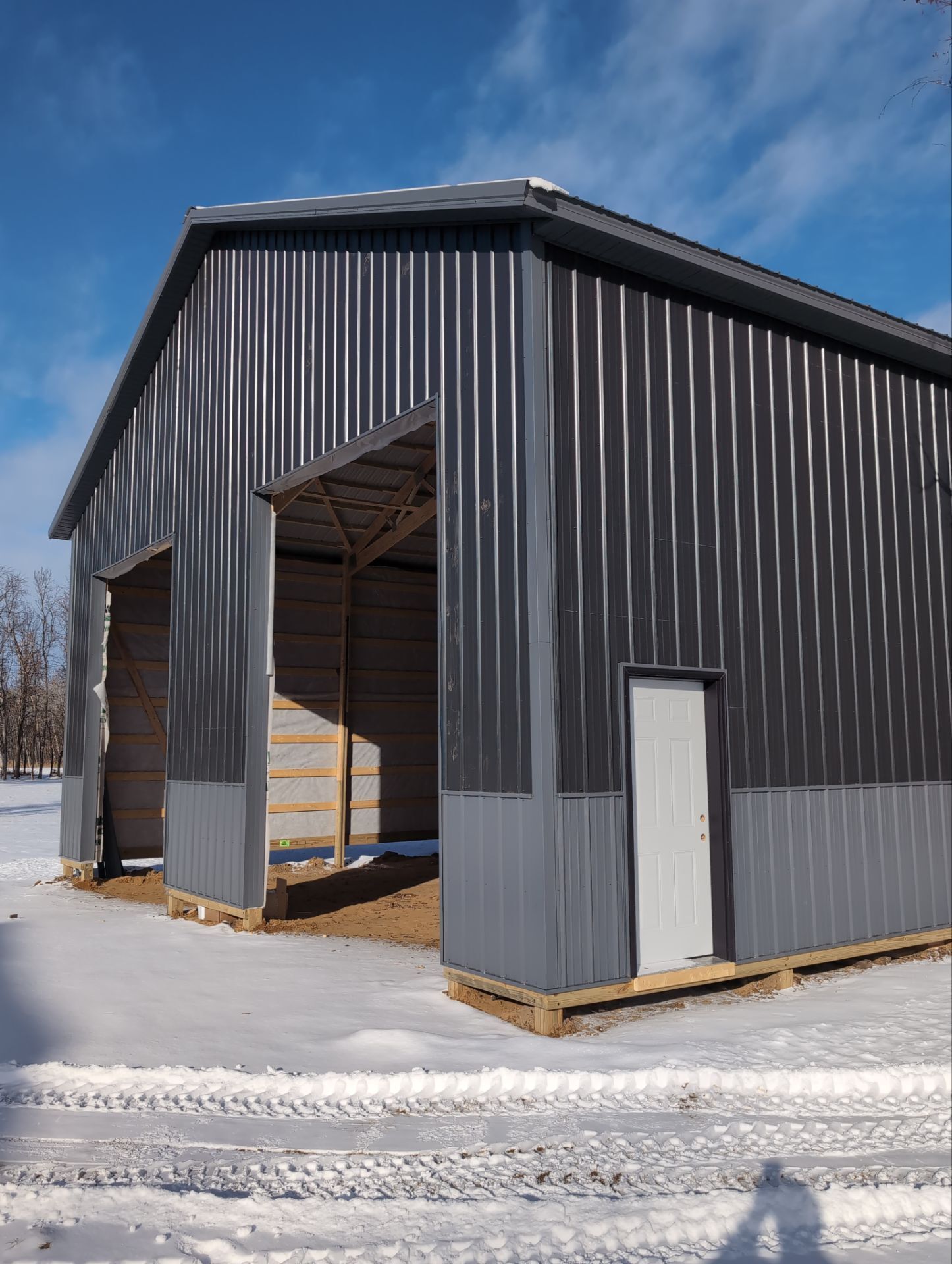 Custom metal pole barn building with vertical steel siding