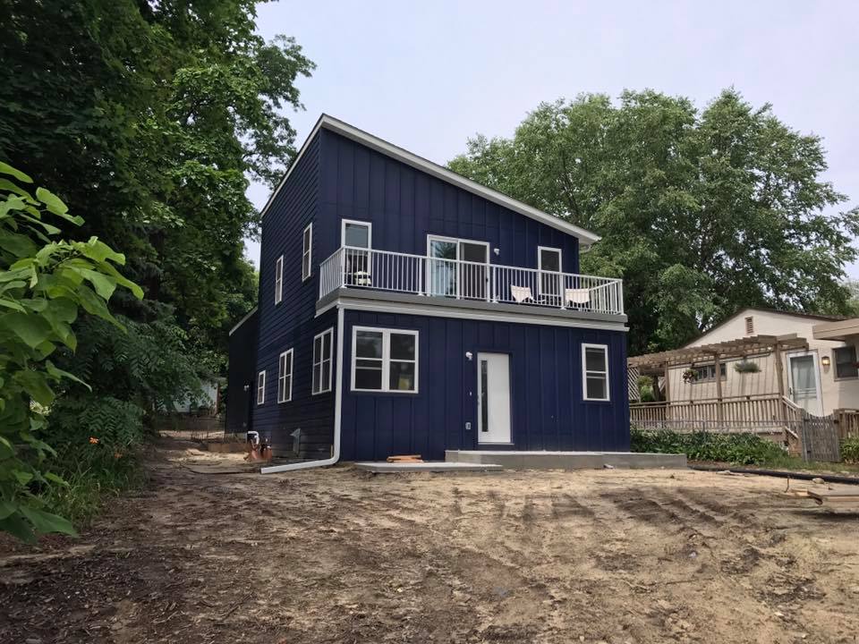 Modern blue two-story home with upper balcony in a custom project in Minnetonka, MN by Willet Remodeling and Construction.