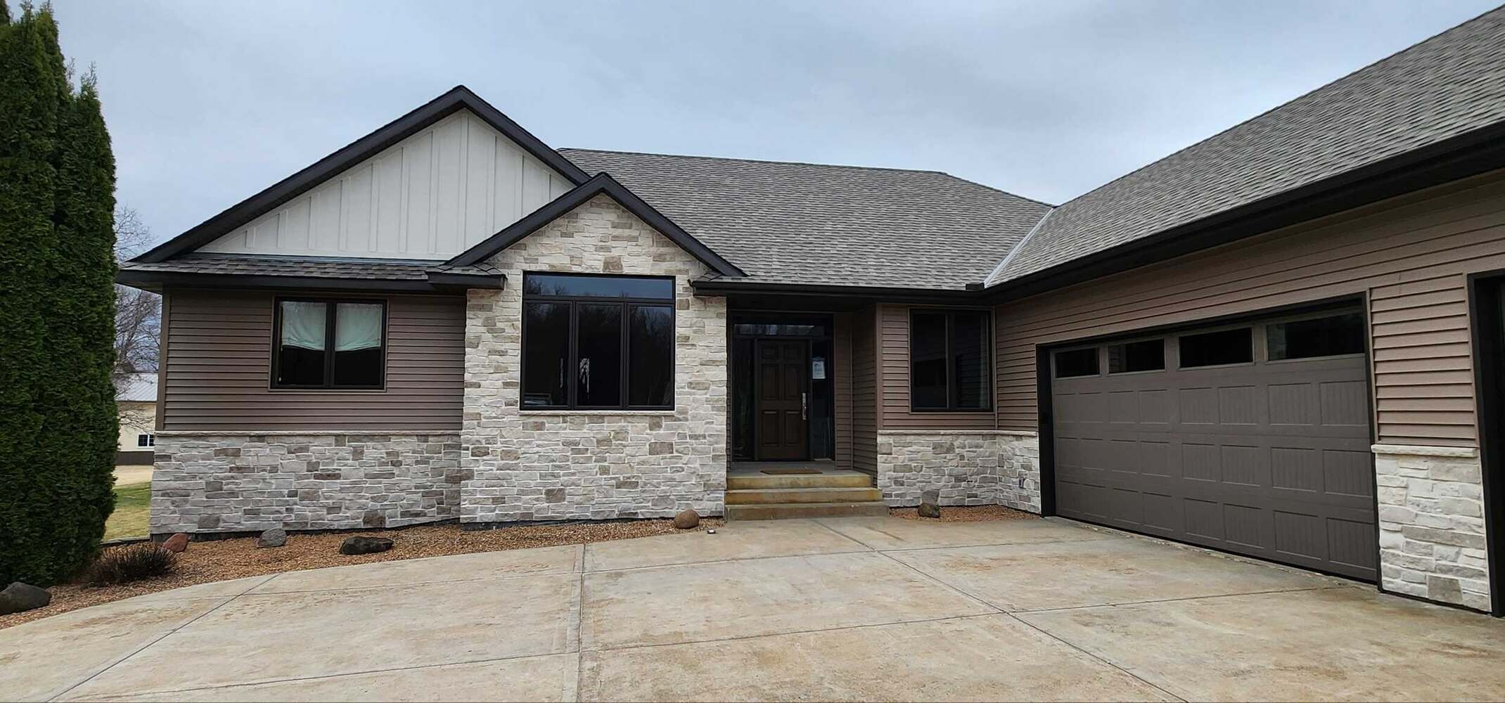 Modern custom home entry with stone and siding accents in Ham Lake, MN by Willet Remodeling and Construction.