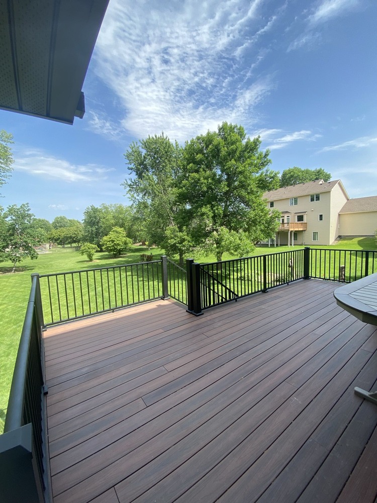 Backyard deck with dark wood-look composite boards by Willet Remodeling and Construction in Edina, MN.