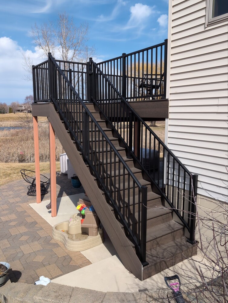 Tall exterior deck with black railing built by Willet Remodeling and Construction in Ramsey, MN.