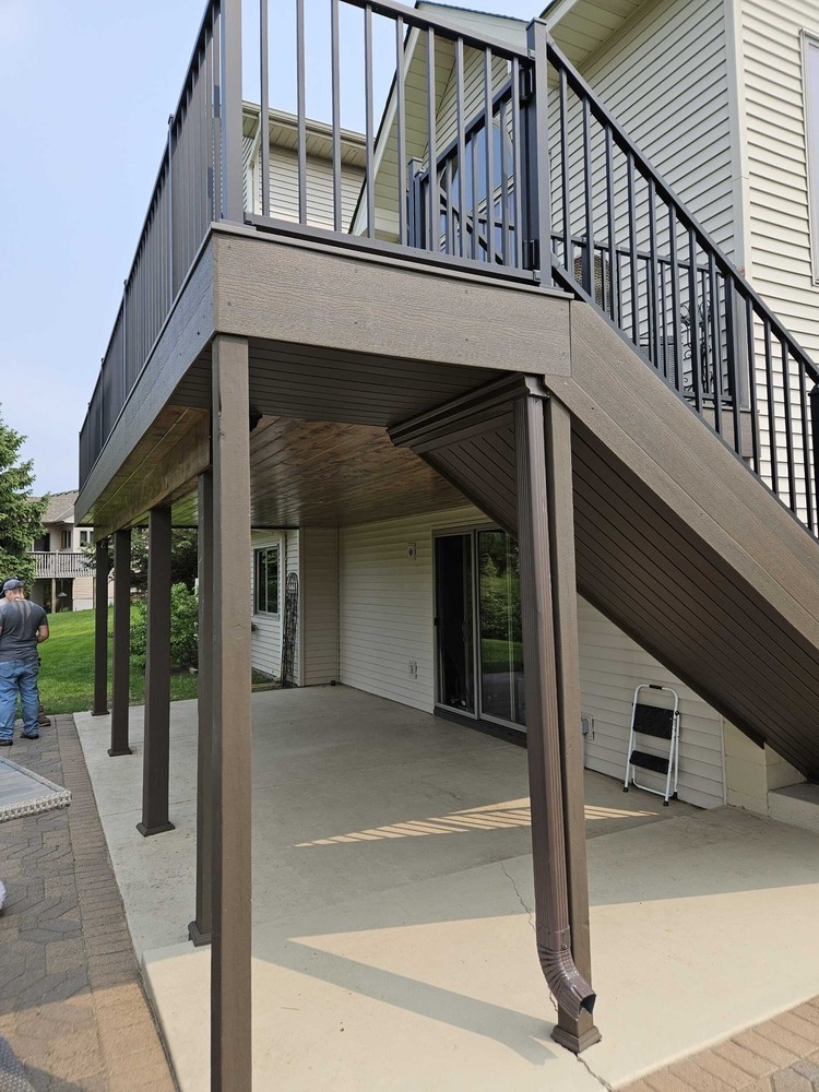 Under-deck space with clean concrete patio by Willet Remodeling and Construction in Nowthen, MN.
